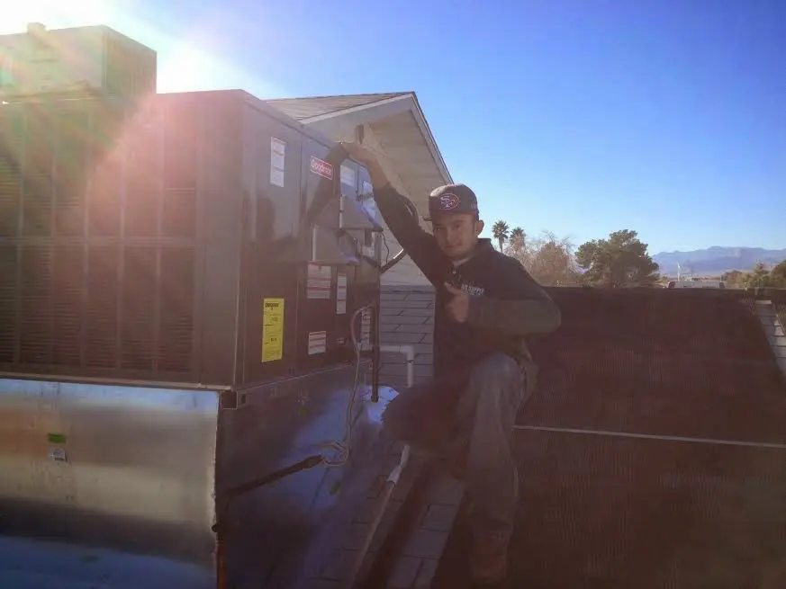HVAC technician performing HVAC Inspection on a rooftop unit in Barton
